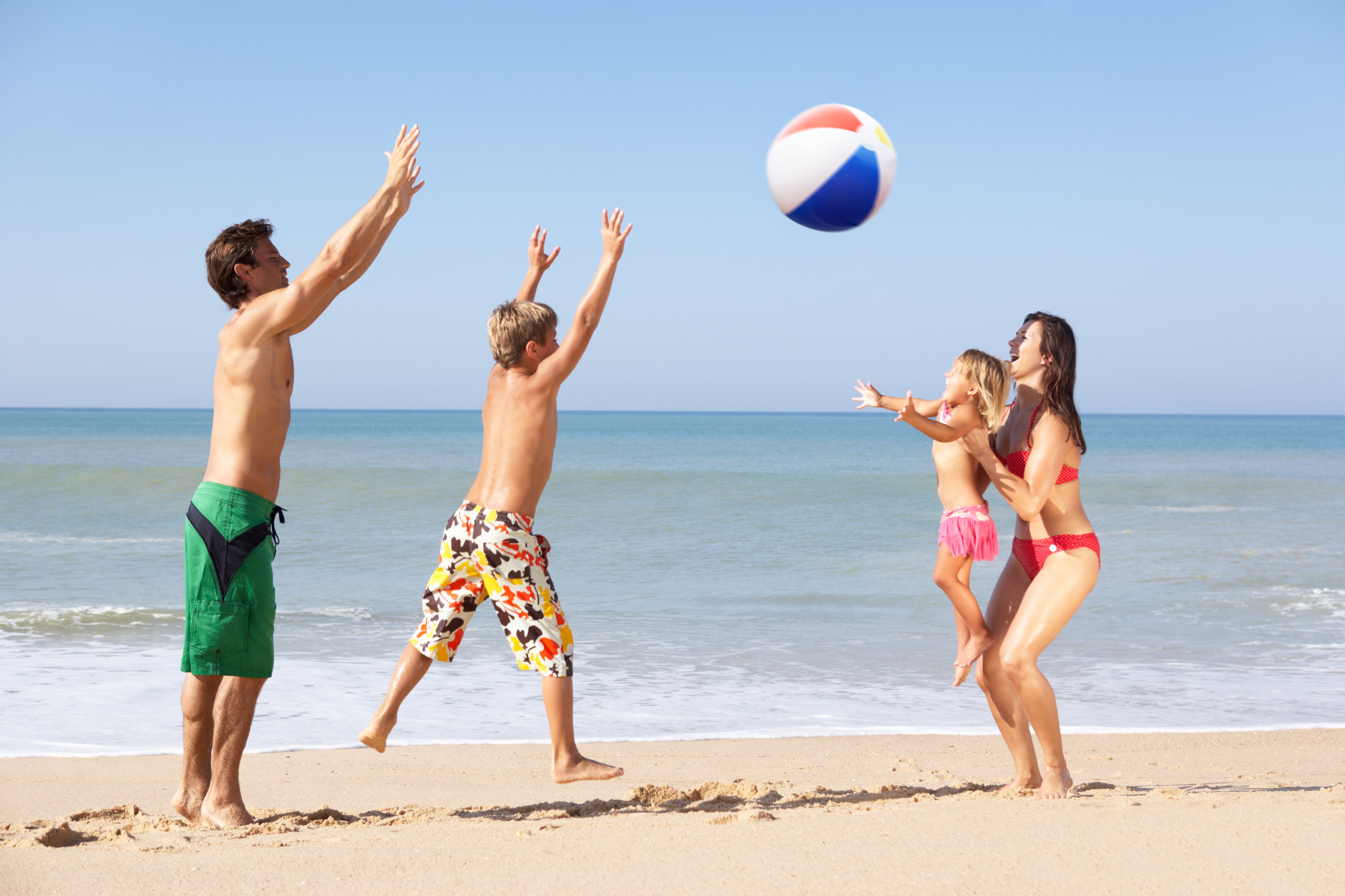 Beach play. Семья на пляже. Семья на море в мяч. На пляже играют в мяч. Развлечения на пляже.